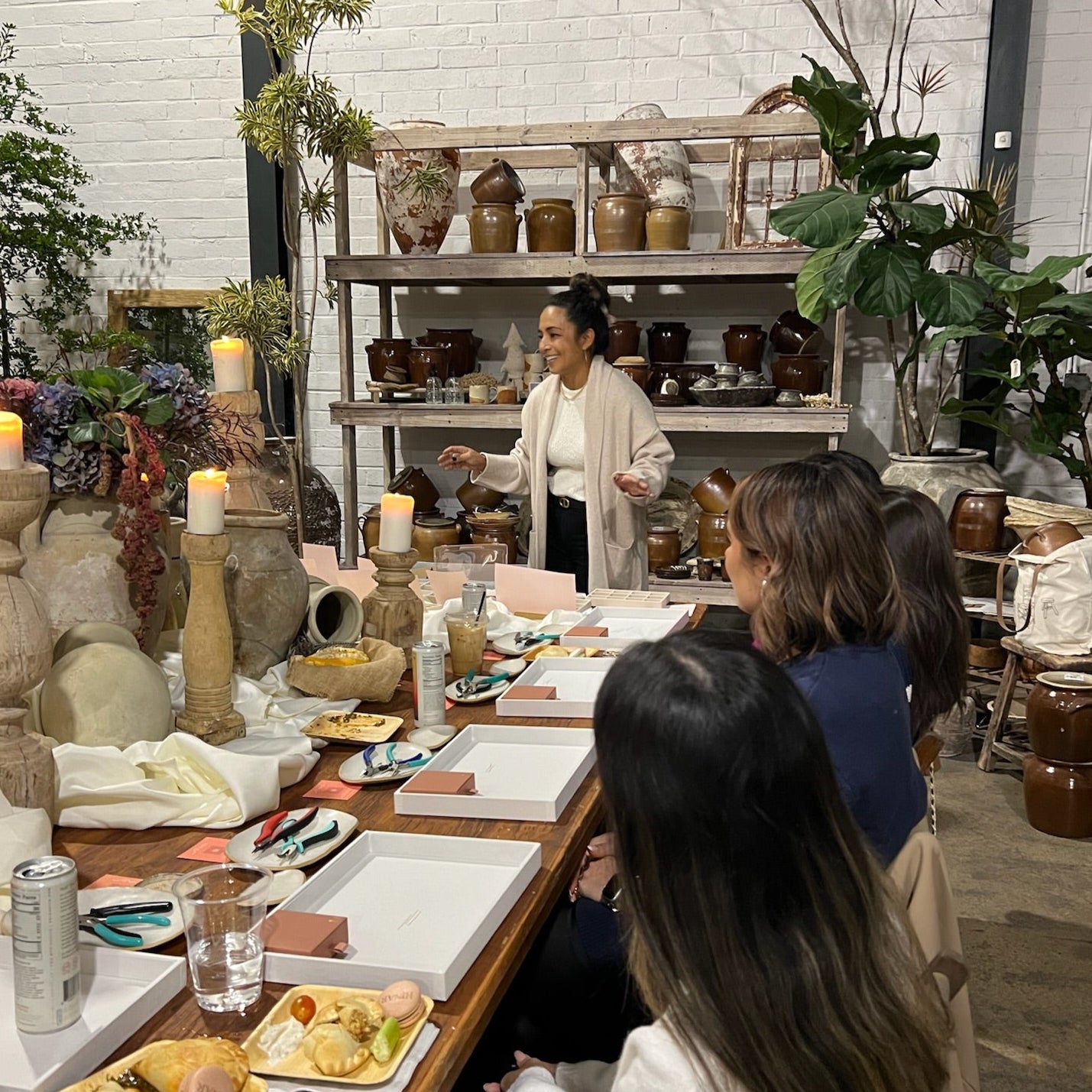 scene of Asian American woman leading a group of women in a jewelry making workshop