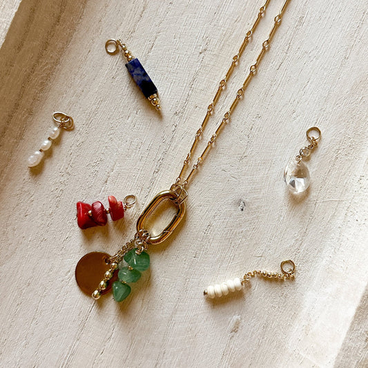 group of charms with various types of stones and a necklace with raw Ecuadorian jade stones