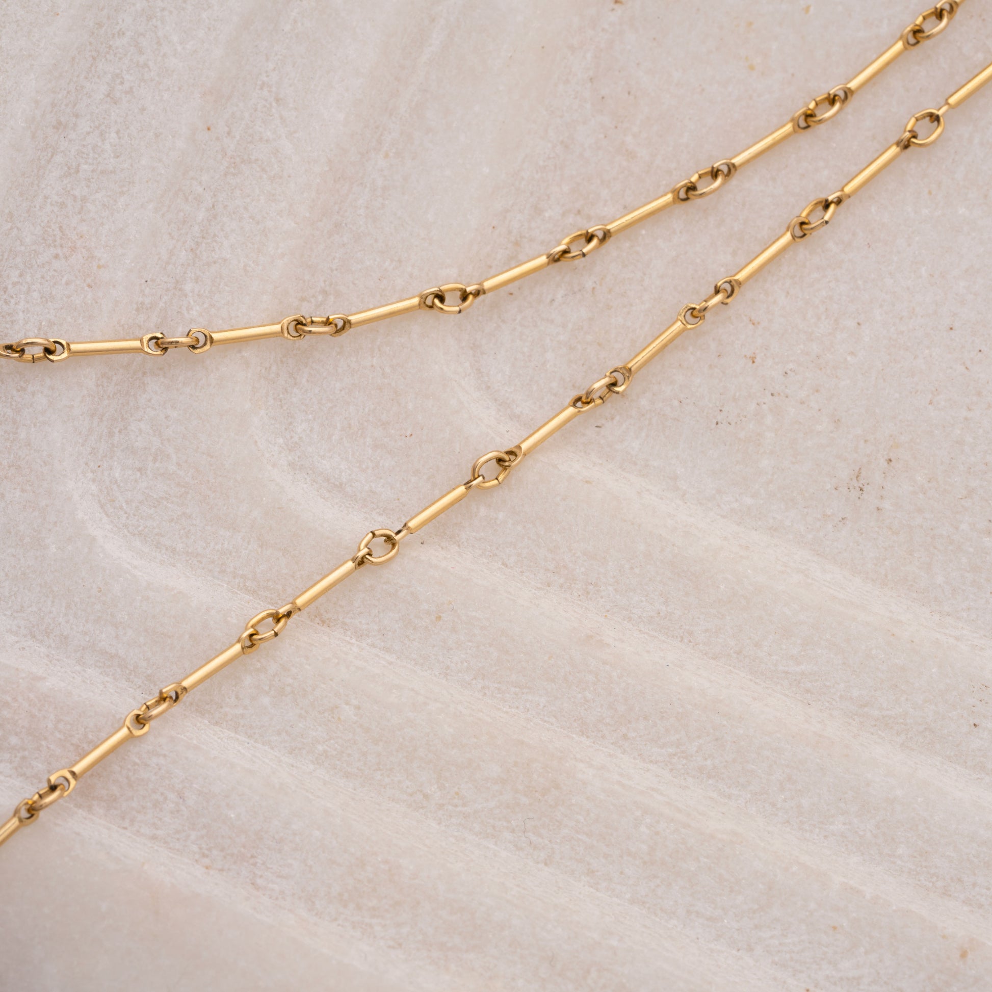 gold-filled necklace chain on a marble tray