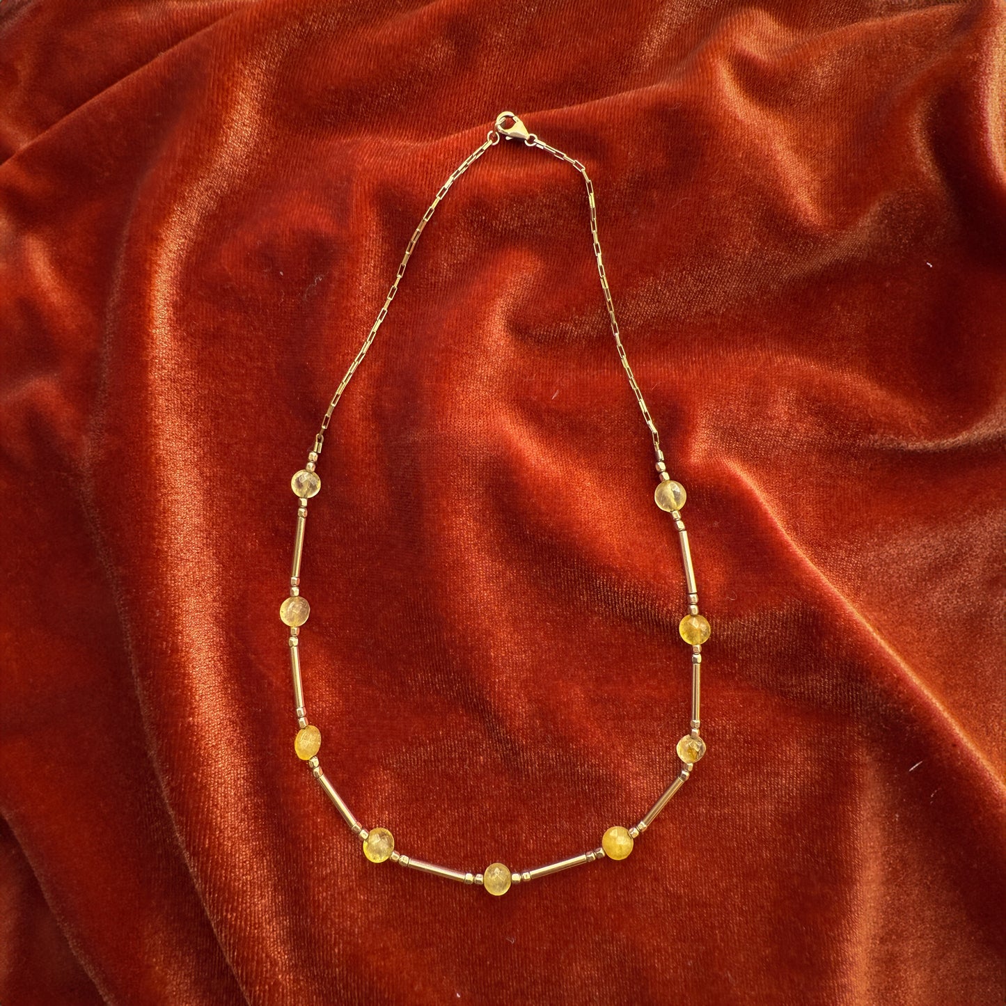 citrine and gold-filled beaded necklace on a red velour cloth