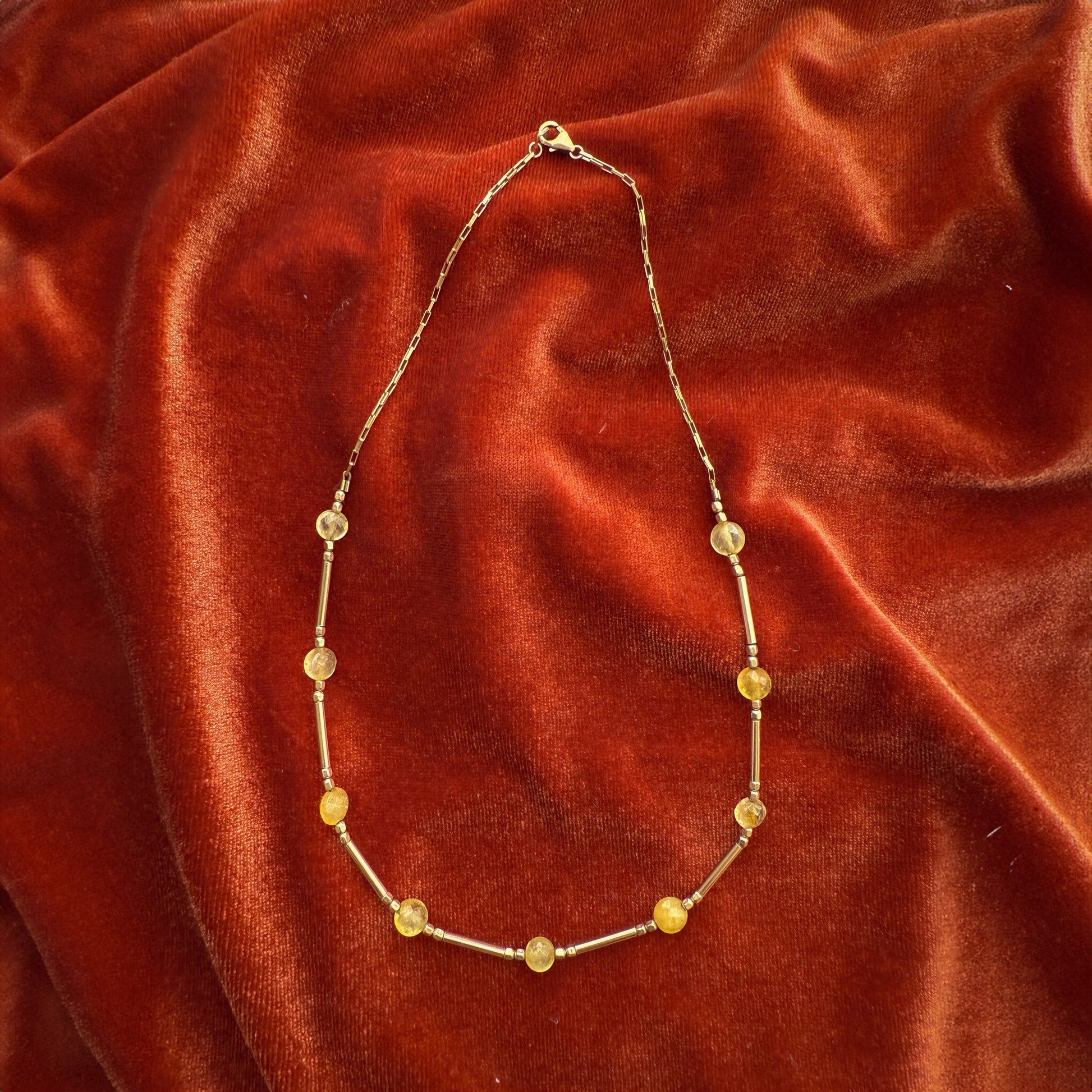 citrine and gold-filled beaded necklace on a red velour cloth