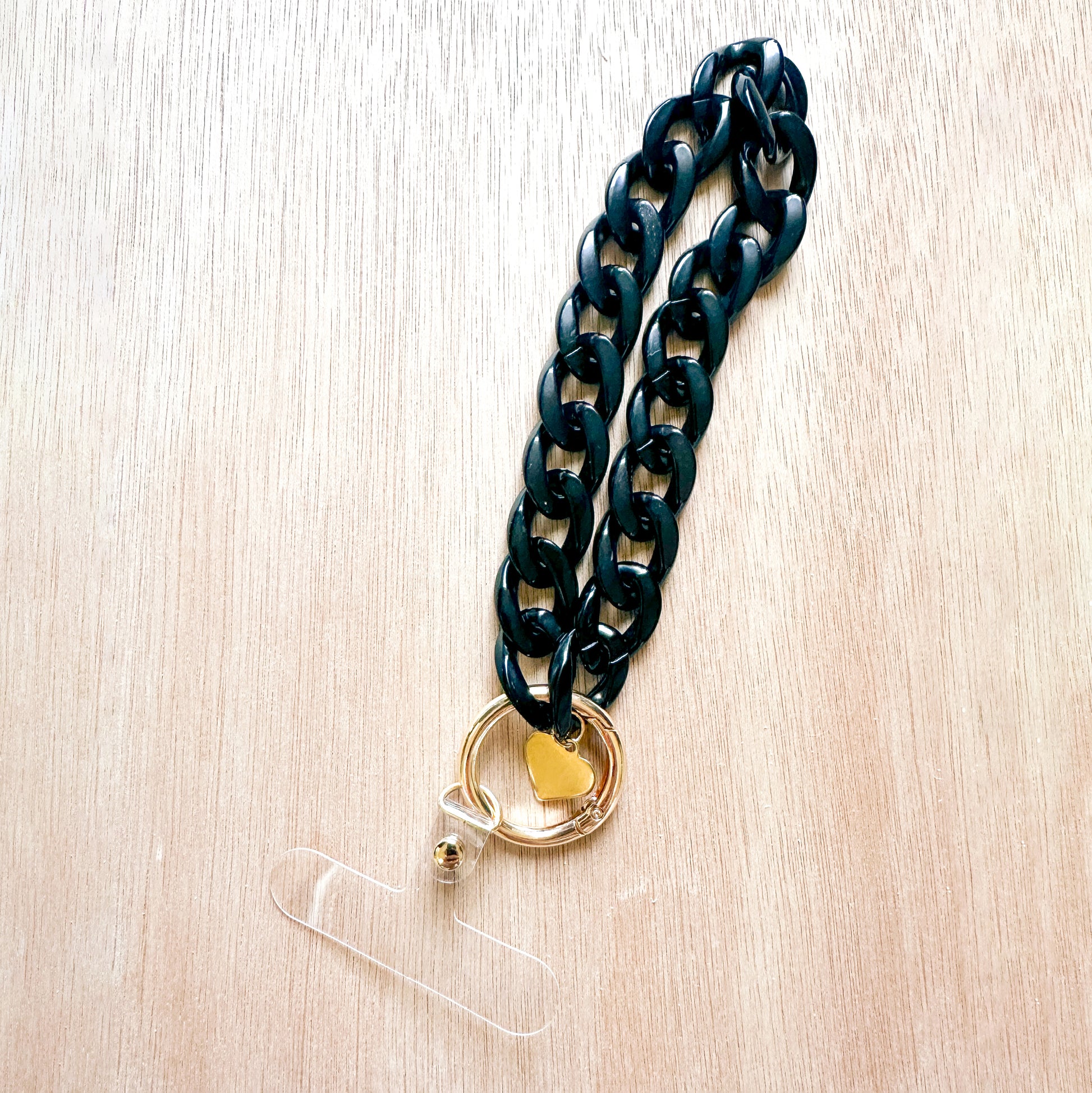 phone bracelet with black acrylic links, gold heart chain, and gold ring