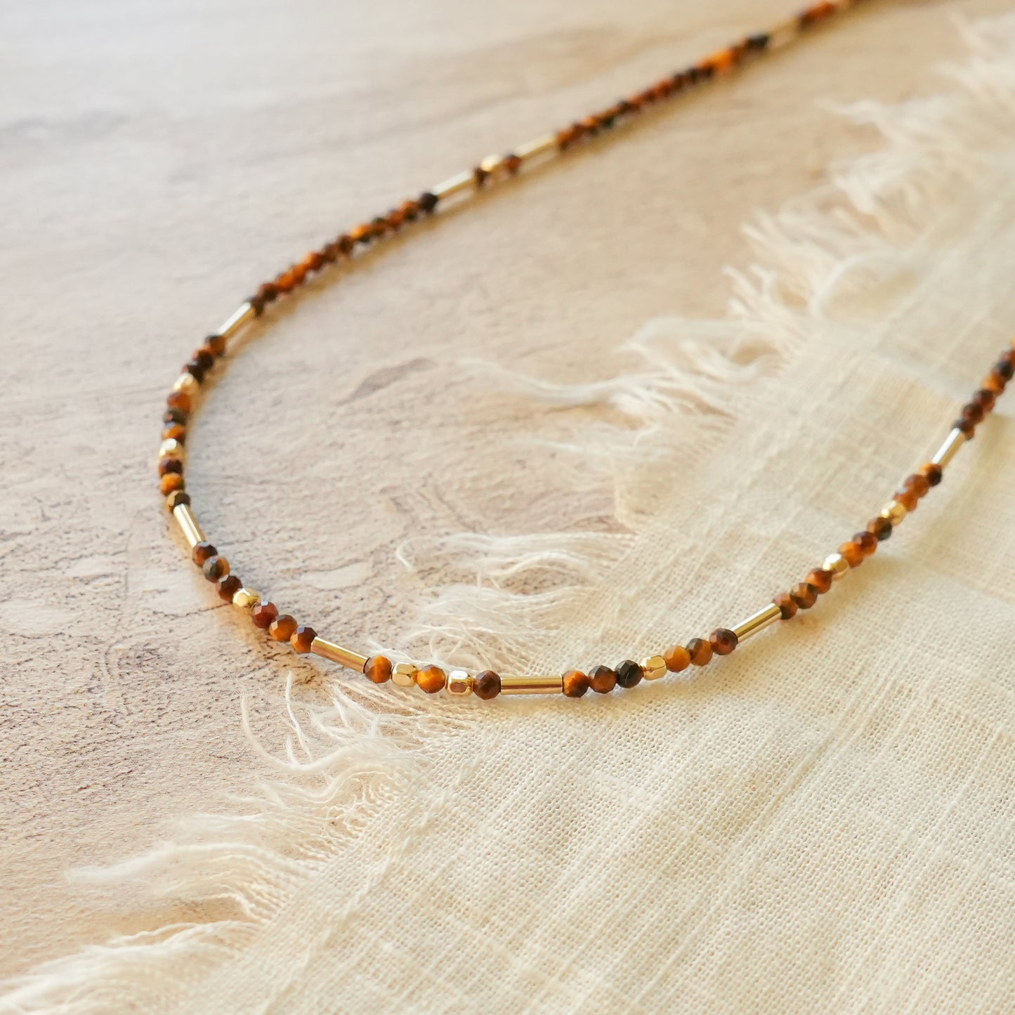 close up view of a necklace with tiger's eye and gold-filled beads