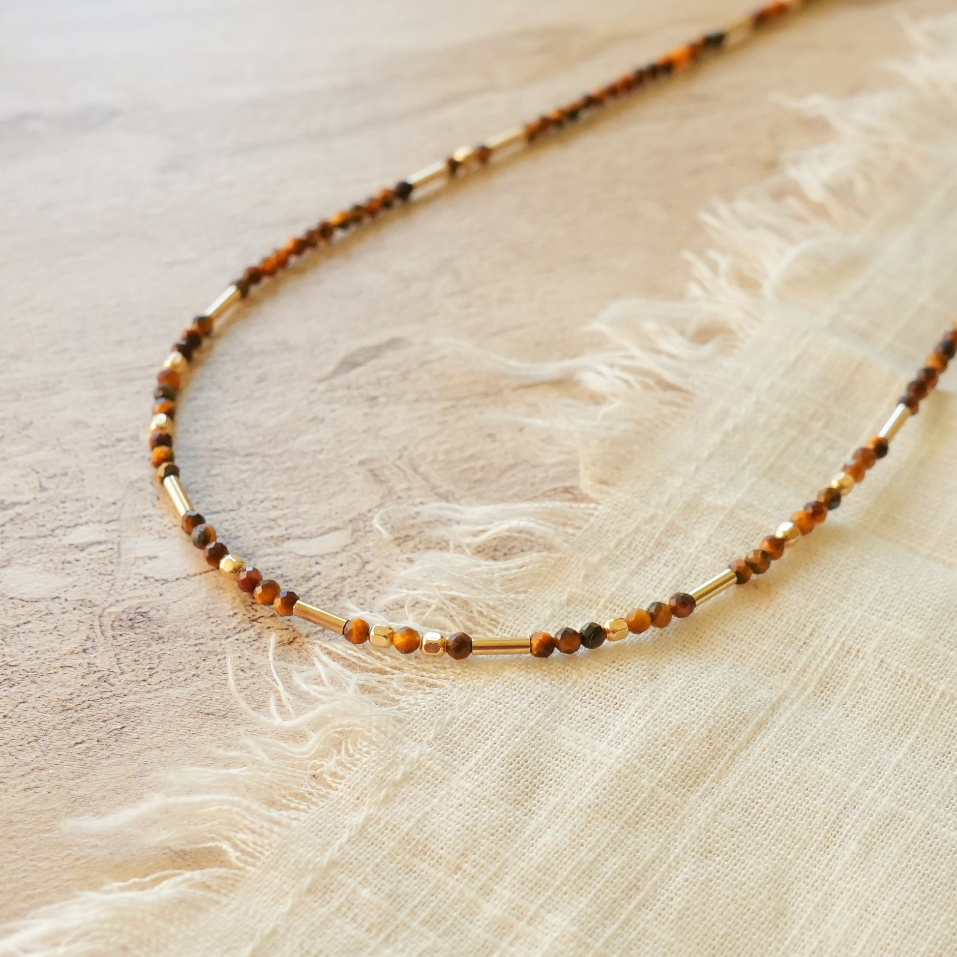 close up view of a necklace with tiger's eye and gold-filled beads
