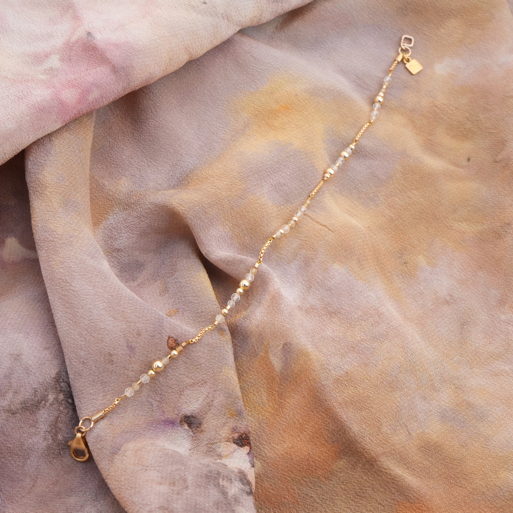citrine and gold-filled bracelet length on a folded multi-color silk cloth