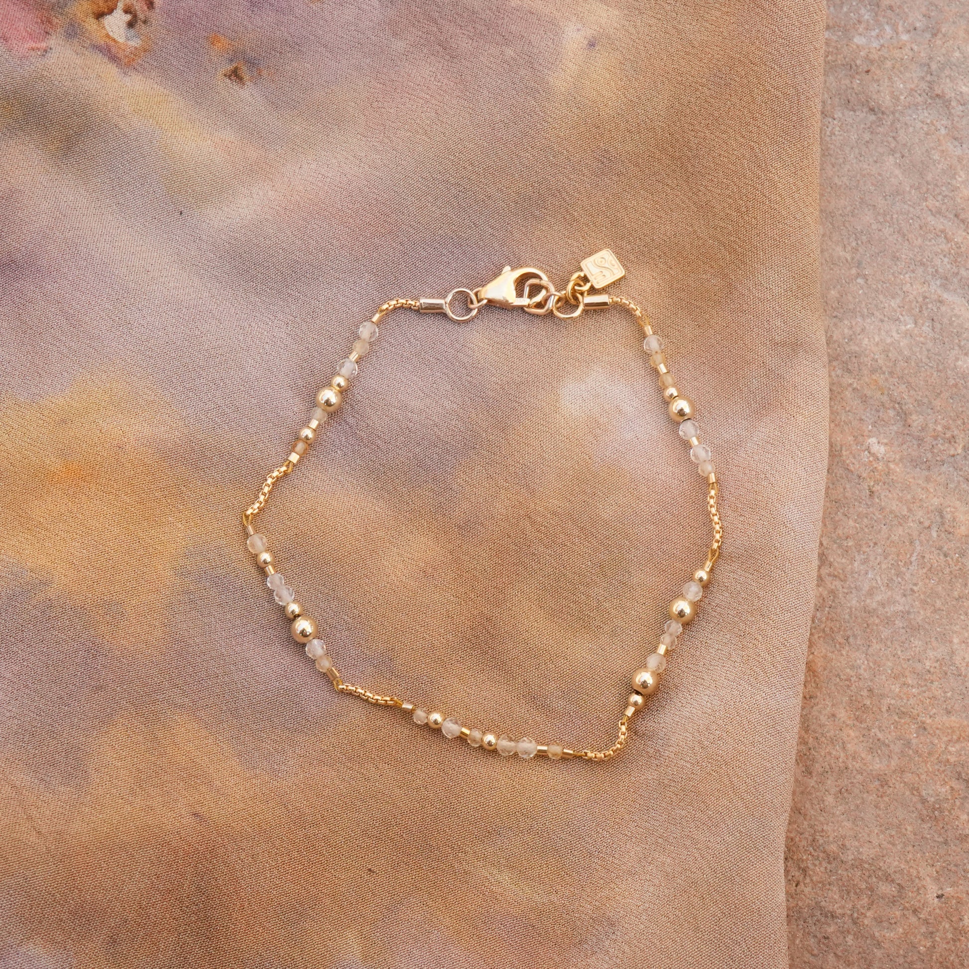 citrine and gold-filled beaded bracelet on a naturally-dyed silk cloth