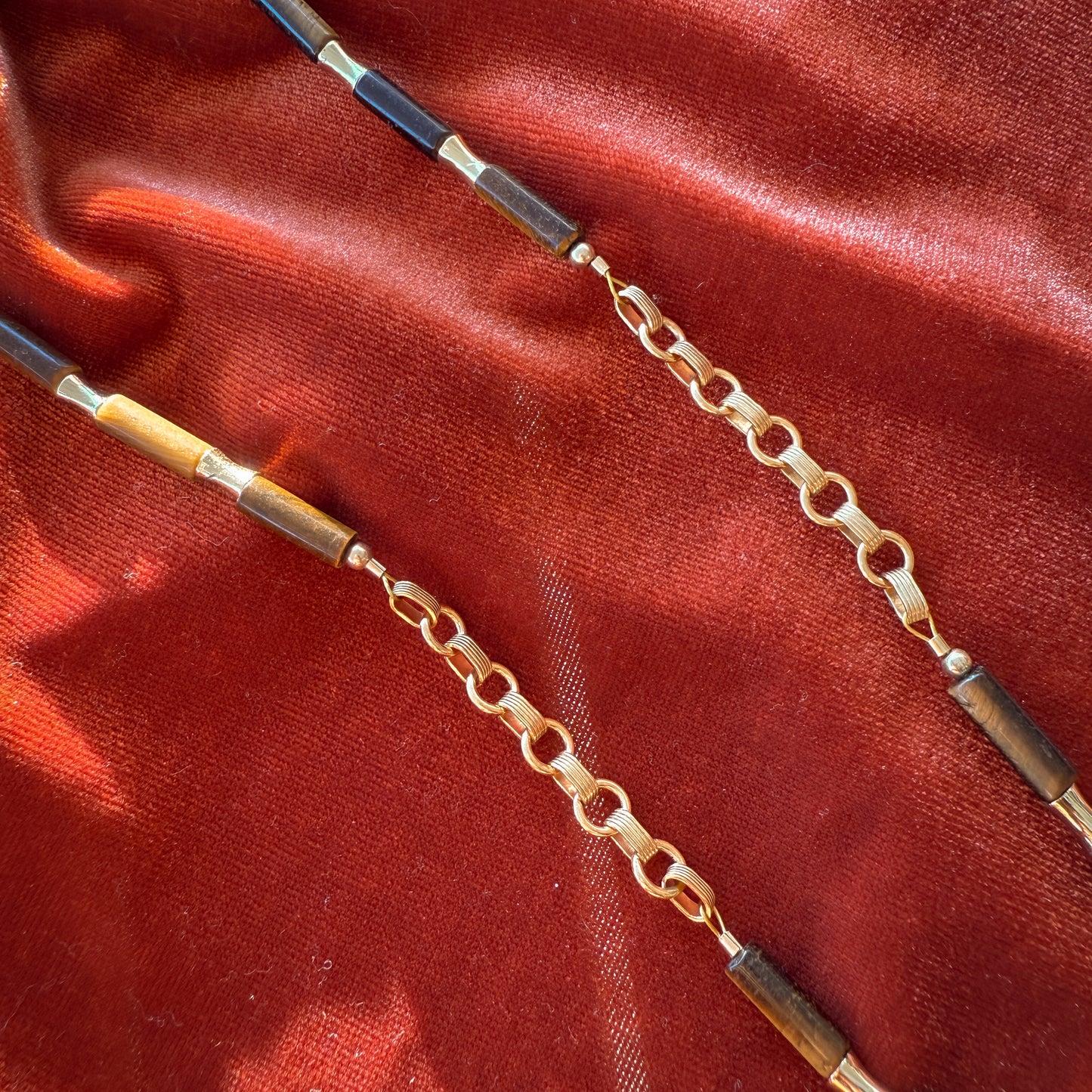 detailed view of gold-filled links, tiger's eye beads, and gold-filled beads on a necklace