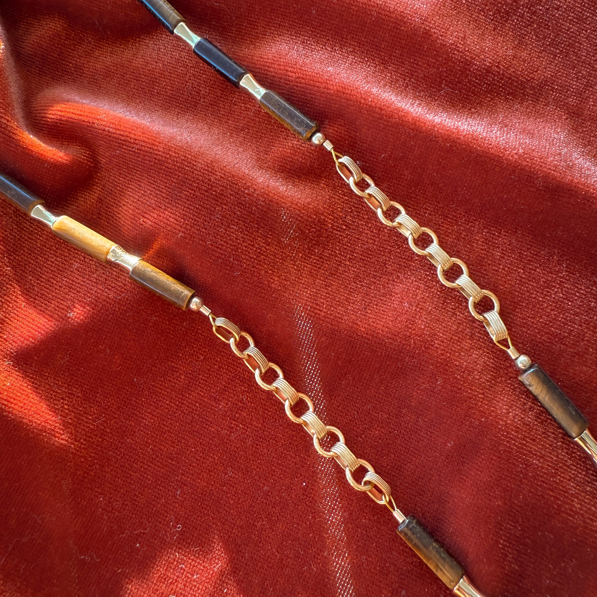 detailed view of gold-filled links, tiger's eye beads, and gold-filled beads on a necklace