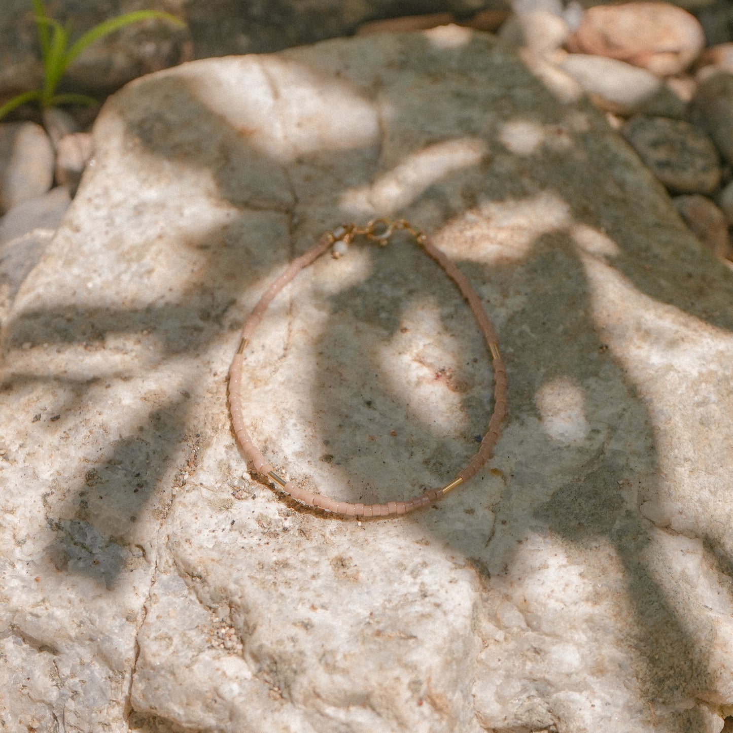 bracelet with Japanese seed beads laying in the shade on a rock