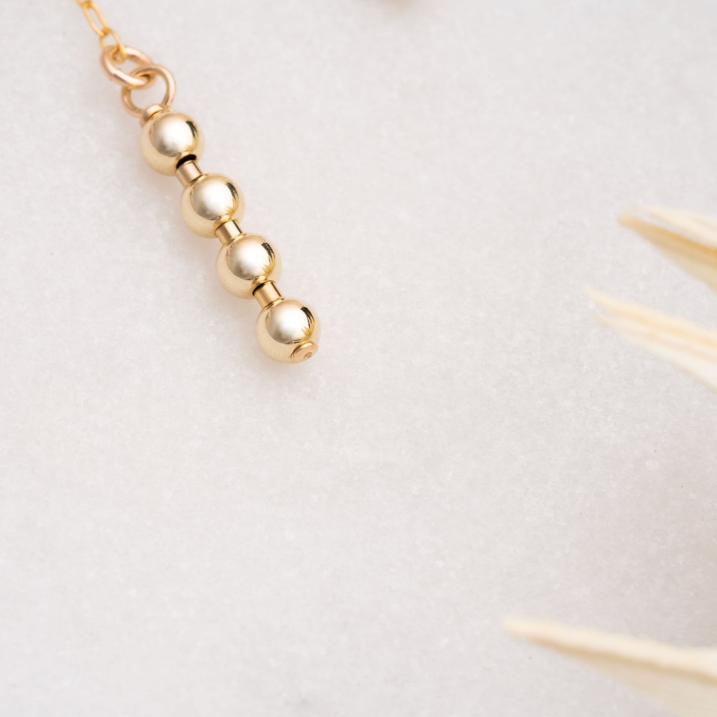 close-up view of 4 gold-filled ball beads on an earring