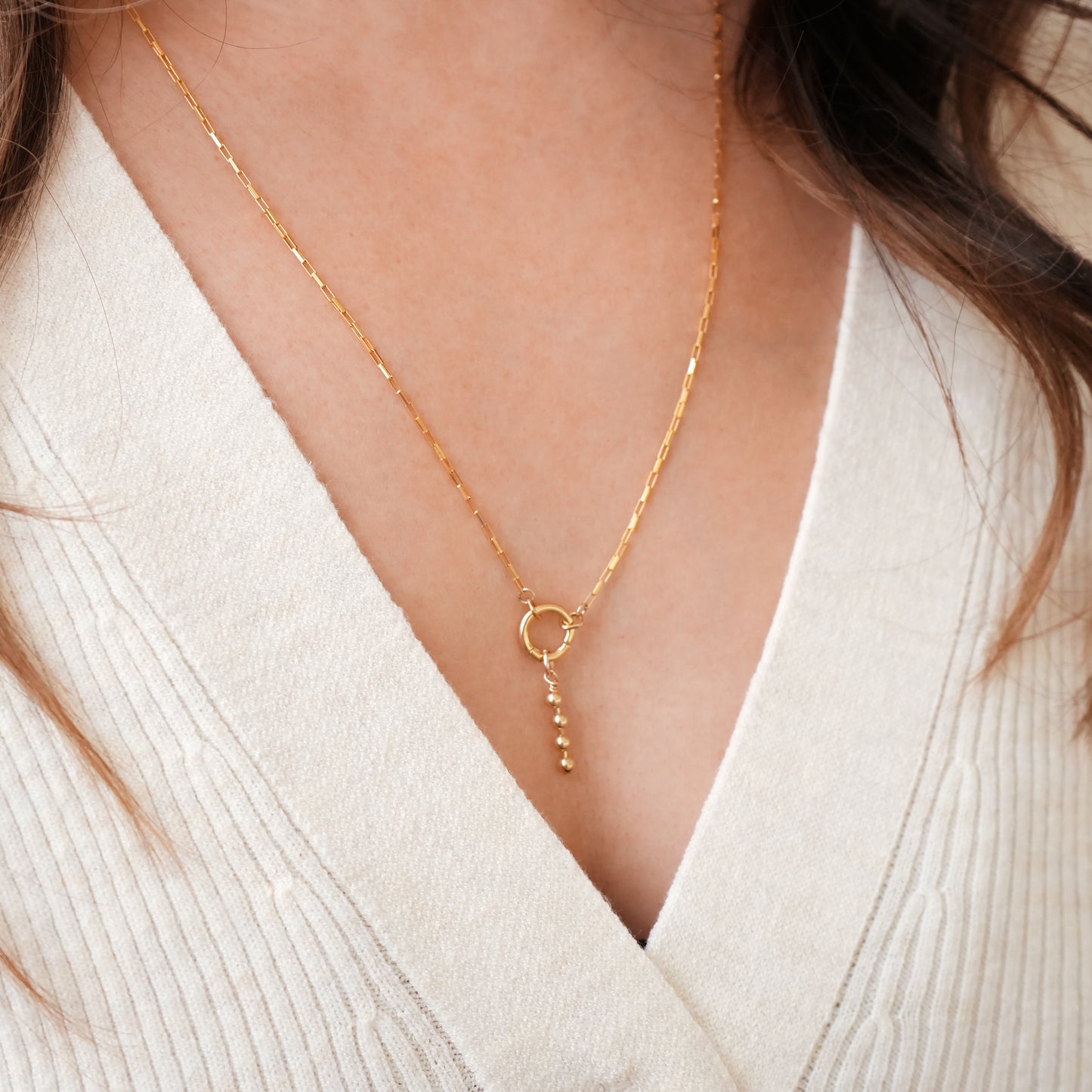woman wearing a gold-filled chain necklace with a front circle clasp and dangling gold-filled beads