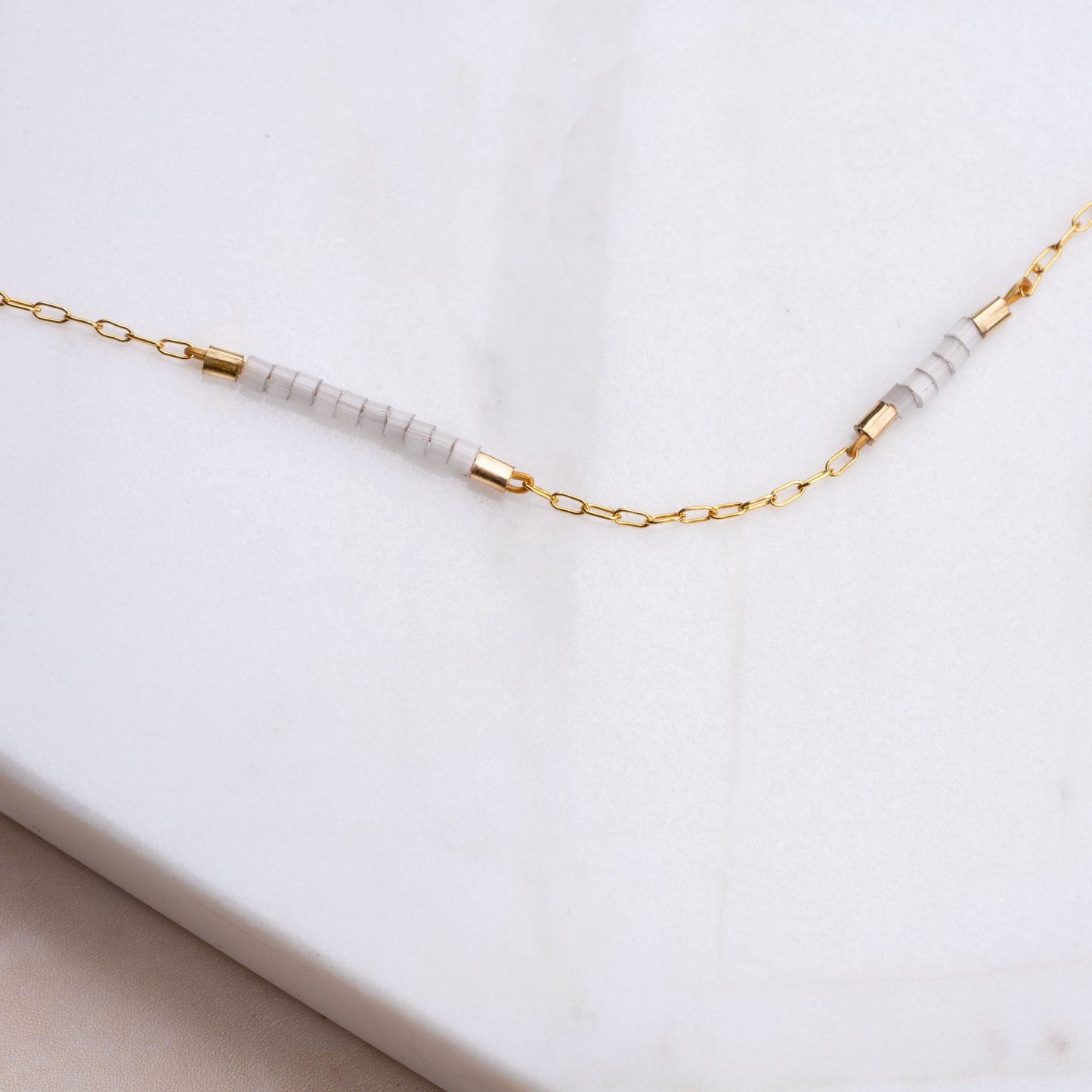 close up view of gold-fill chain and white and gold-fill beads on a bracelet
