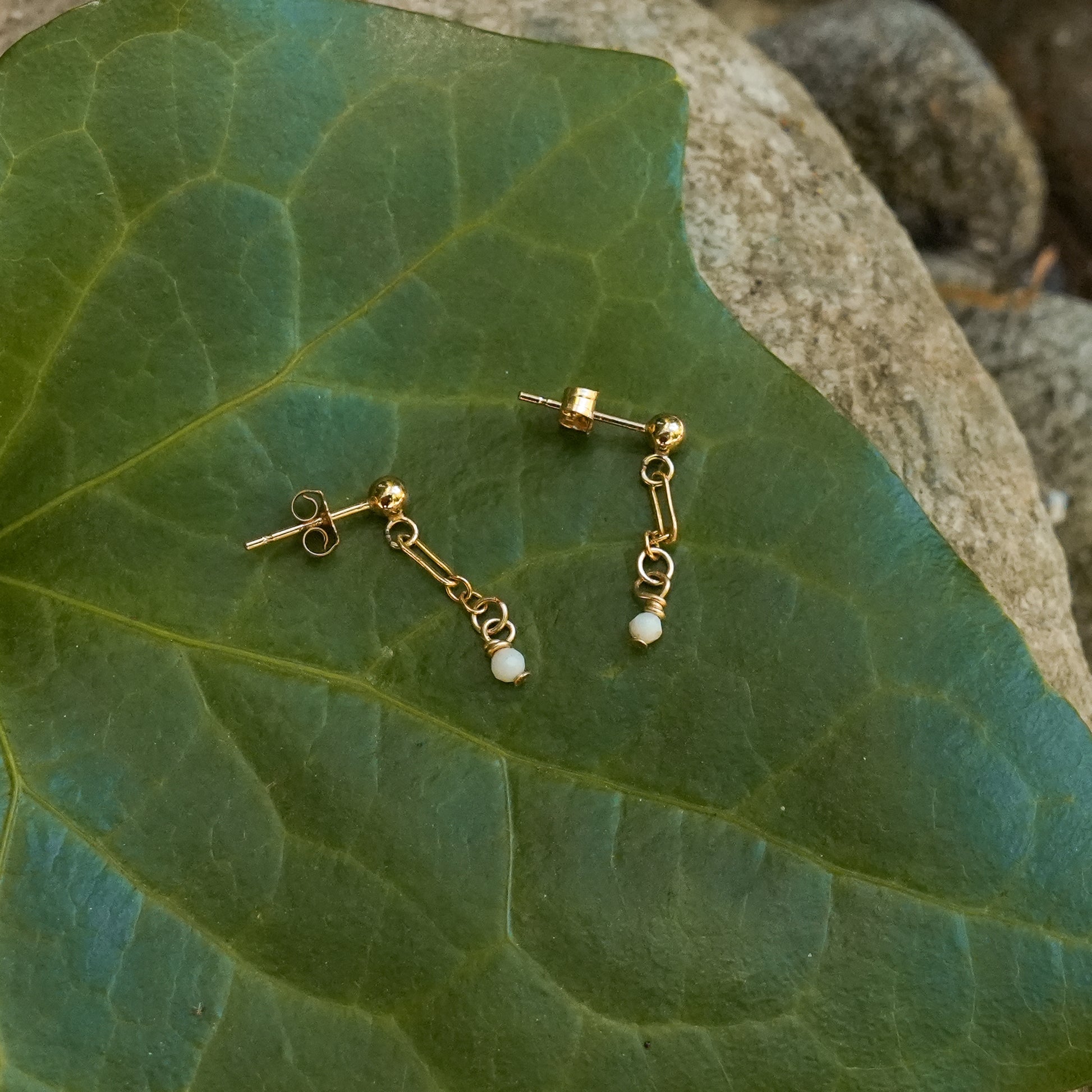 earrings with australian opal and gold-fill chains on a leaf