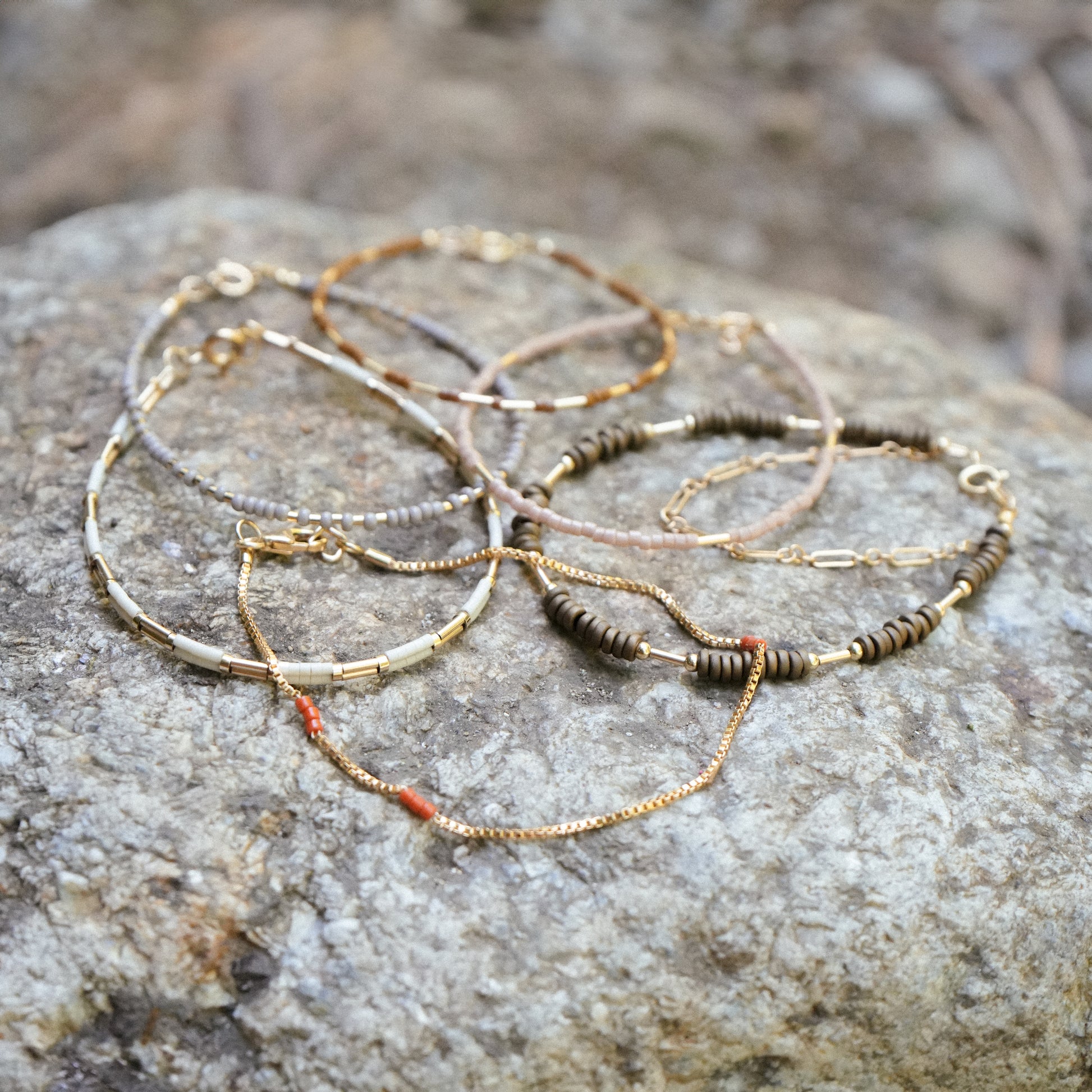bundle of six beaded bracelets resting on a boulder