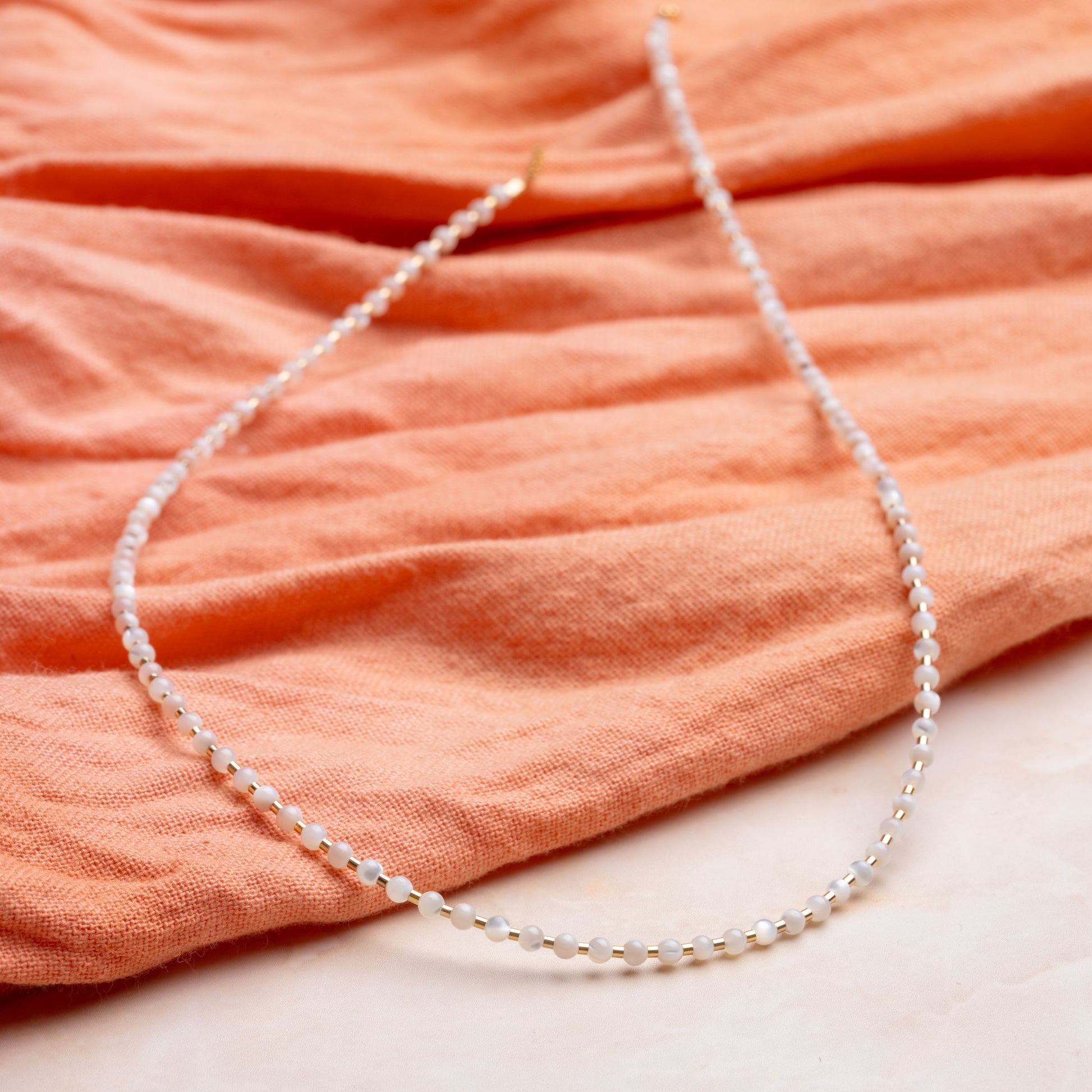 necklace with mother of pearl and gold-fill beads on a coral cloth