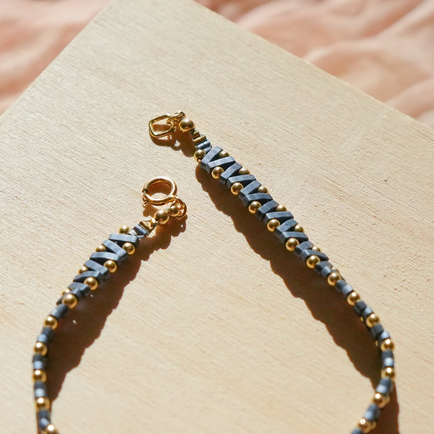 close up view of bracelet with blue-gray Japanese glass beads and a gold-fill clasp
