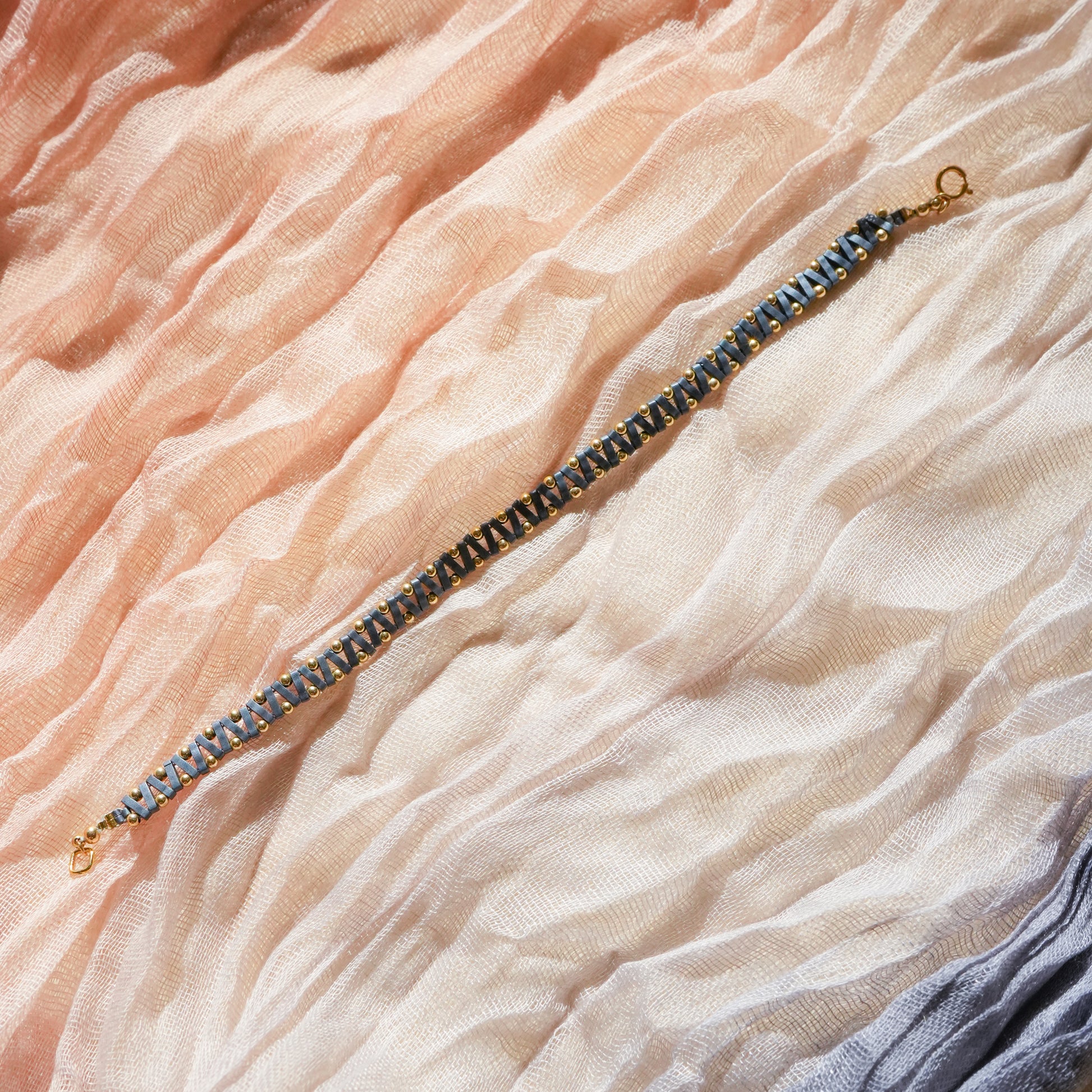 unclasped bracelet with blue-gray Japanese glass beads on a colorful scarf