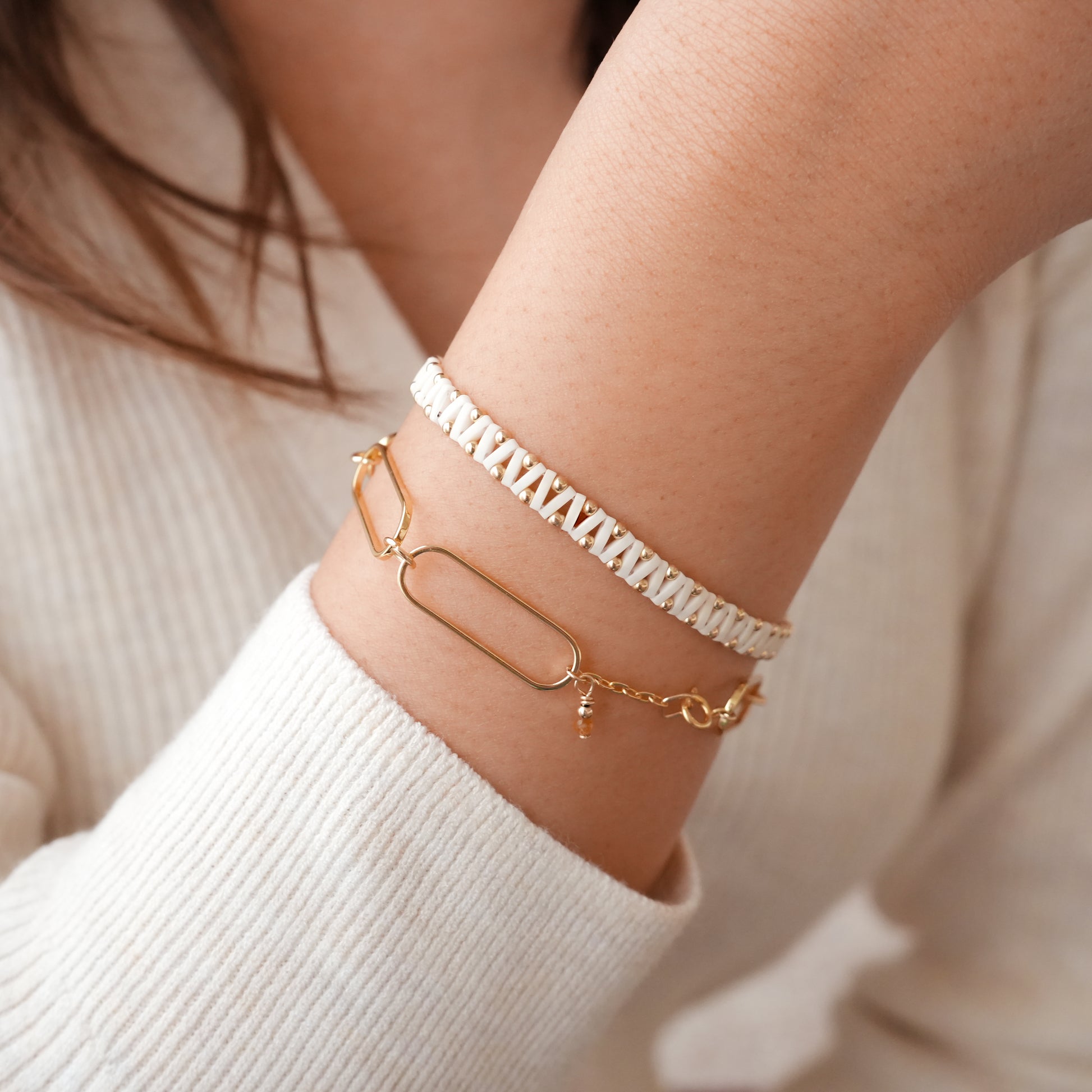 woman's wrist with two gold-fill beaded bracelets