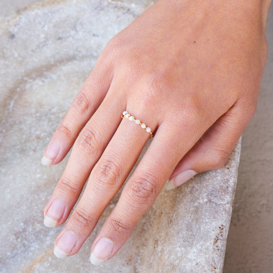 woman's hand with a ring containing white moonstone faceted quartz stones