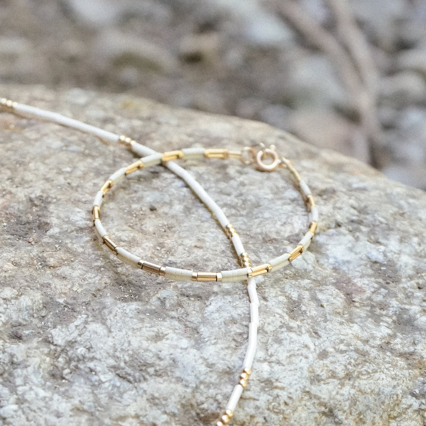 bracelet and necklace resting on a rock