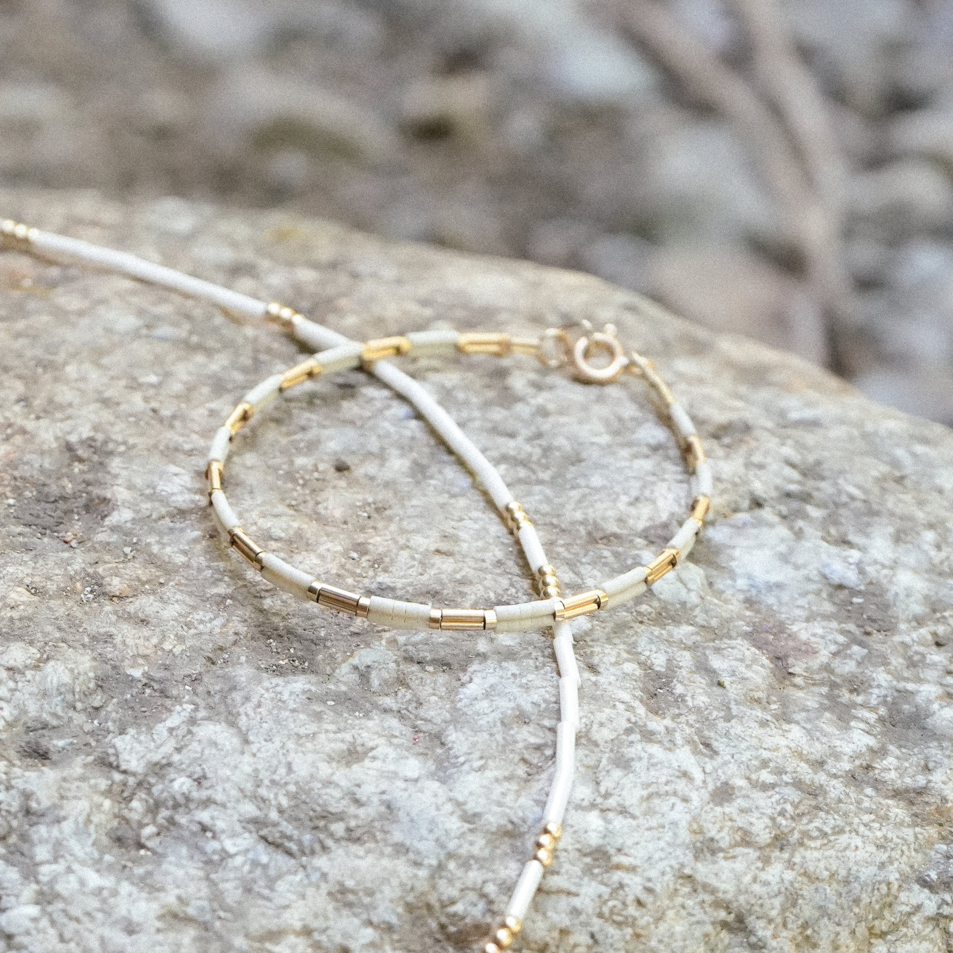 bracelet and necklace resting on a rock
