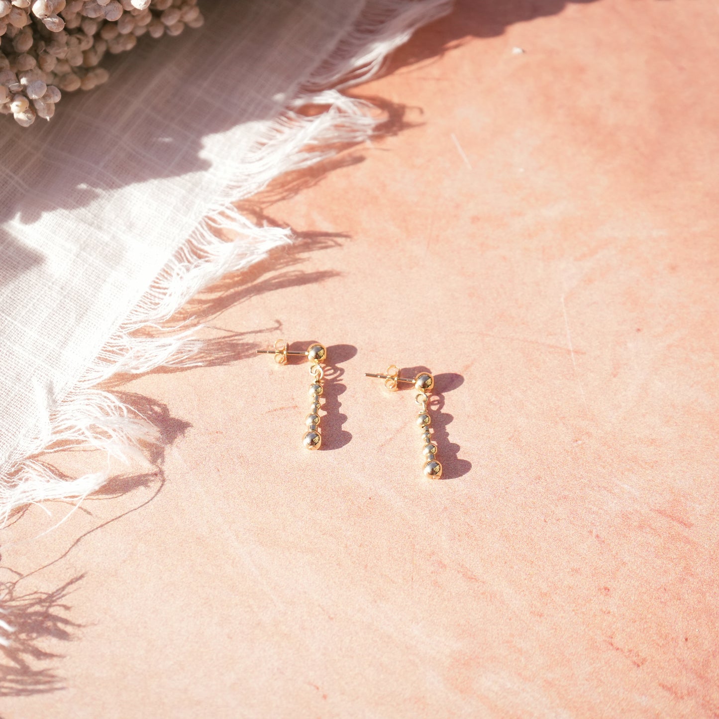 14k gold-fill beaded earrings on a coral background