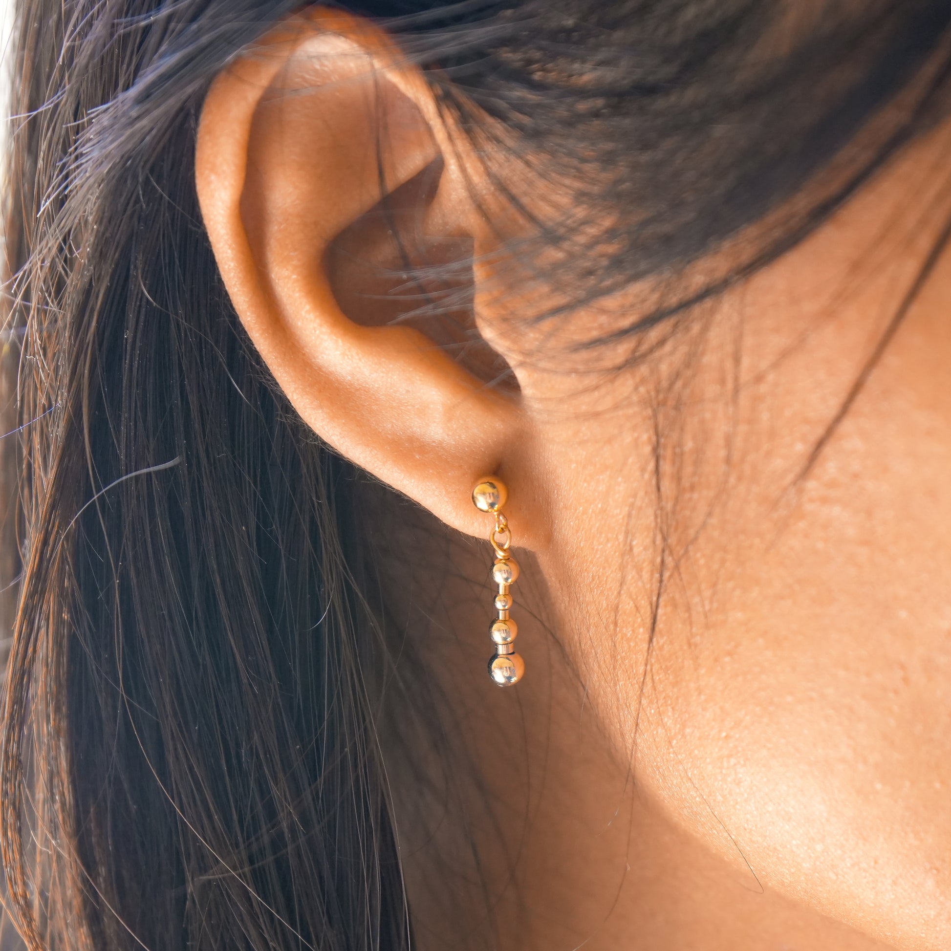 woman's ear with 14k gold-fill beaded earring