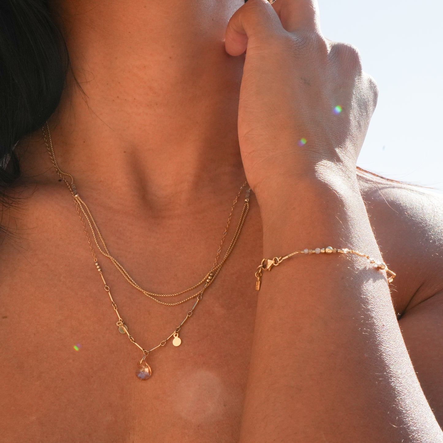 woman wearing two necklaces and a bracelet with gold-filled chains and beads