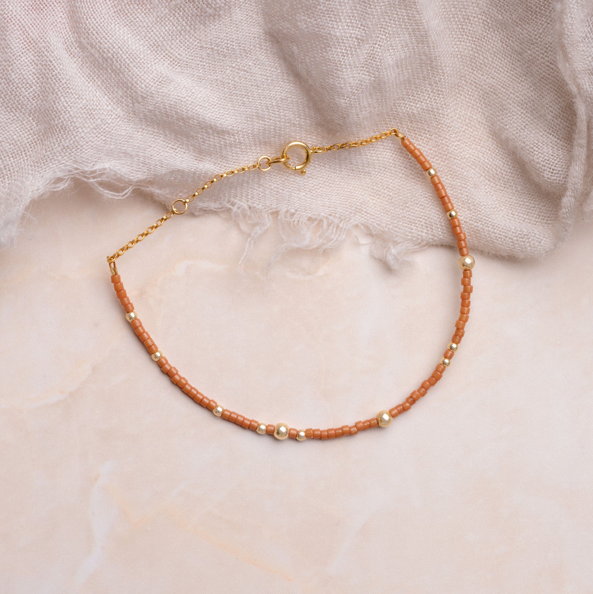 brown miyuki glass bead bracelet on a white cloth