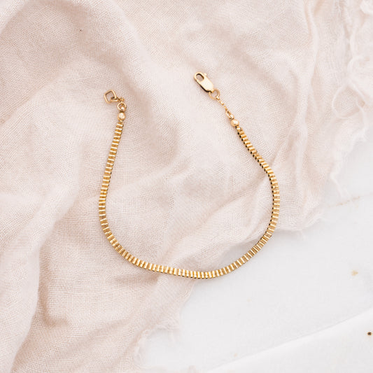 gold-filled beaded bracelet on white cloth