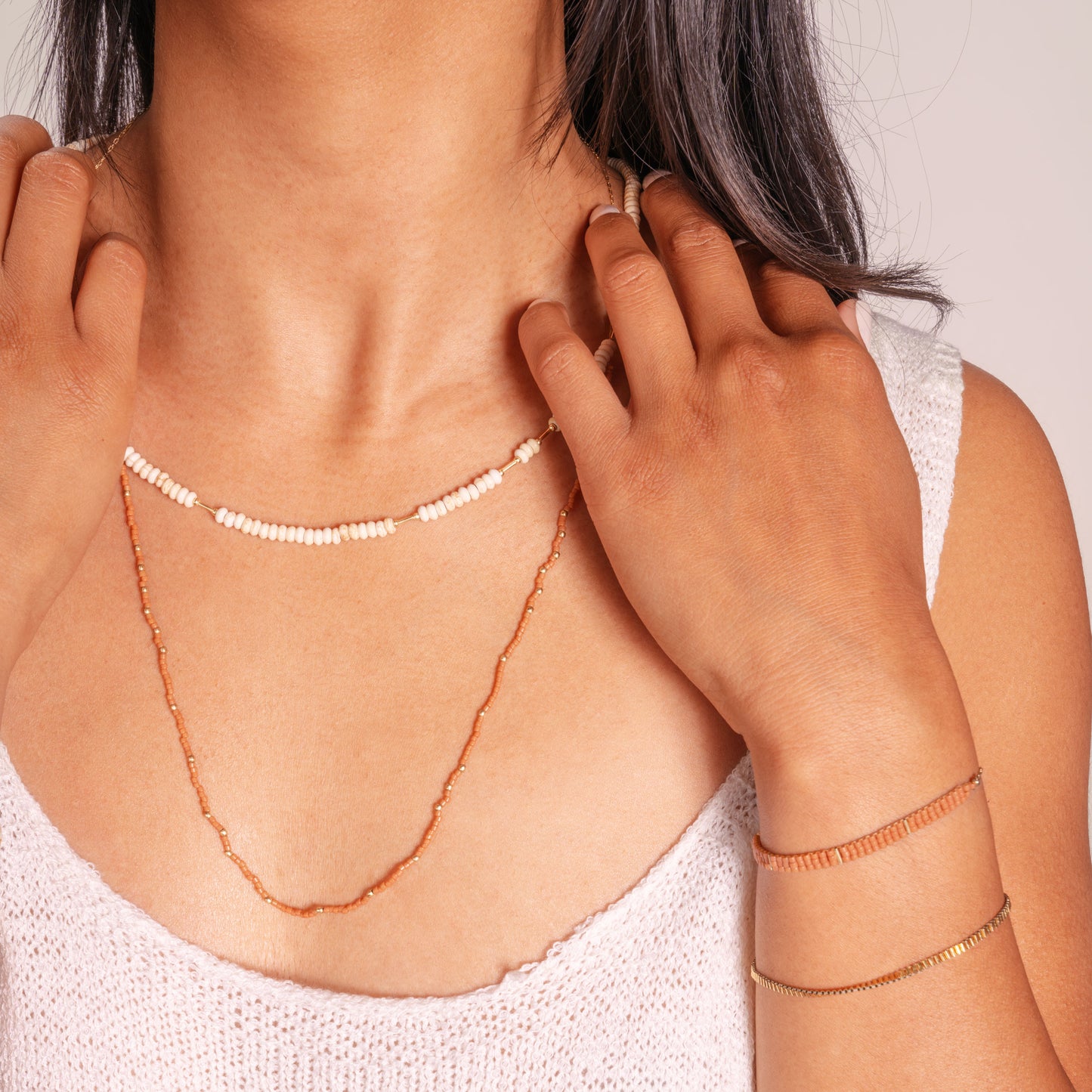 woman wearing beaded necklaces and bracelets