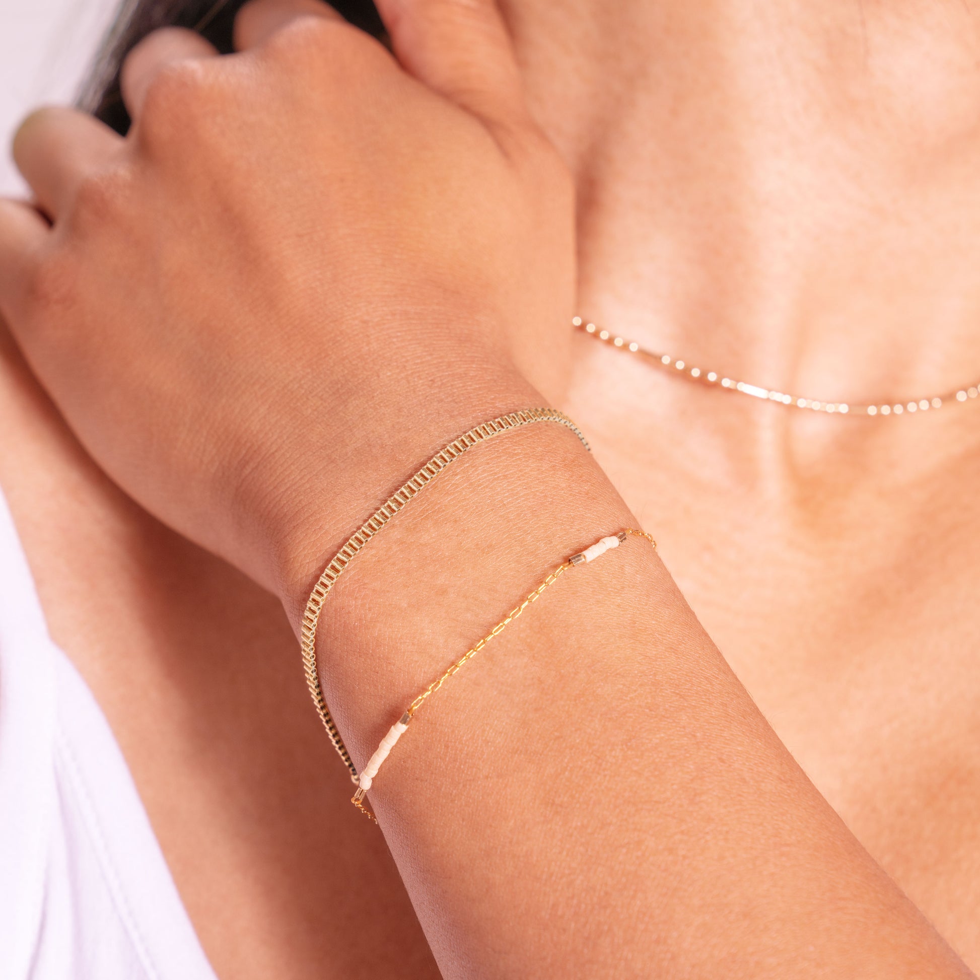 woman's wrist with a gold-filled beaded bracelet