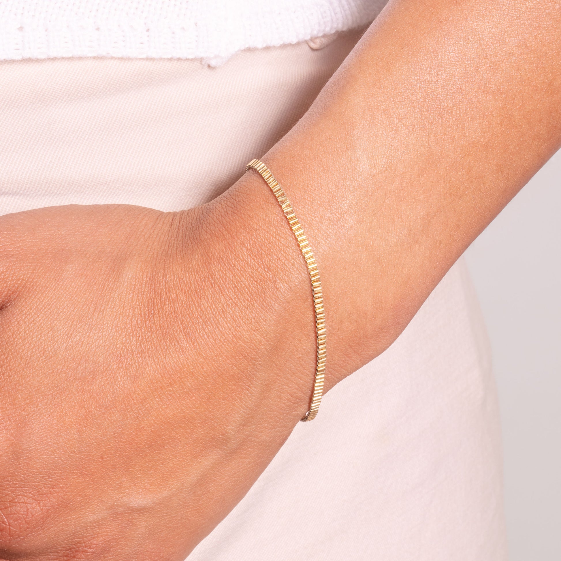 woman's wrist with gold-filled beaded bracelet