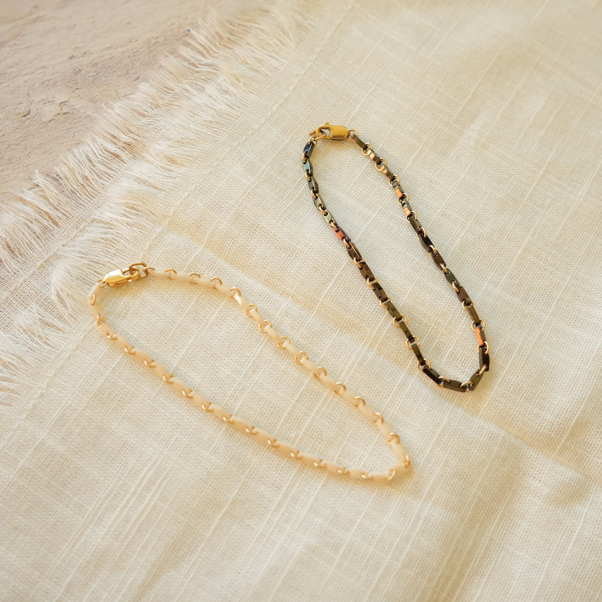 black and white bracelets with Japanese glass beads and circle chain links on a white cloth