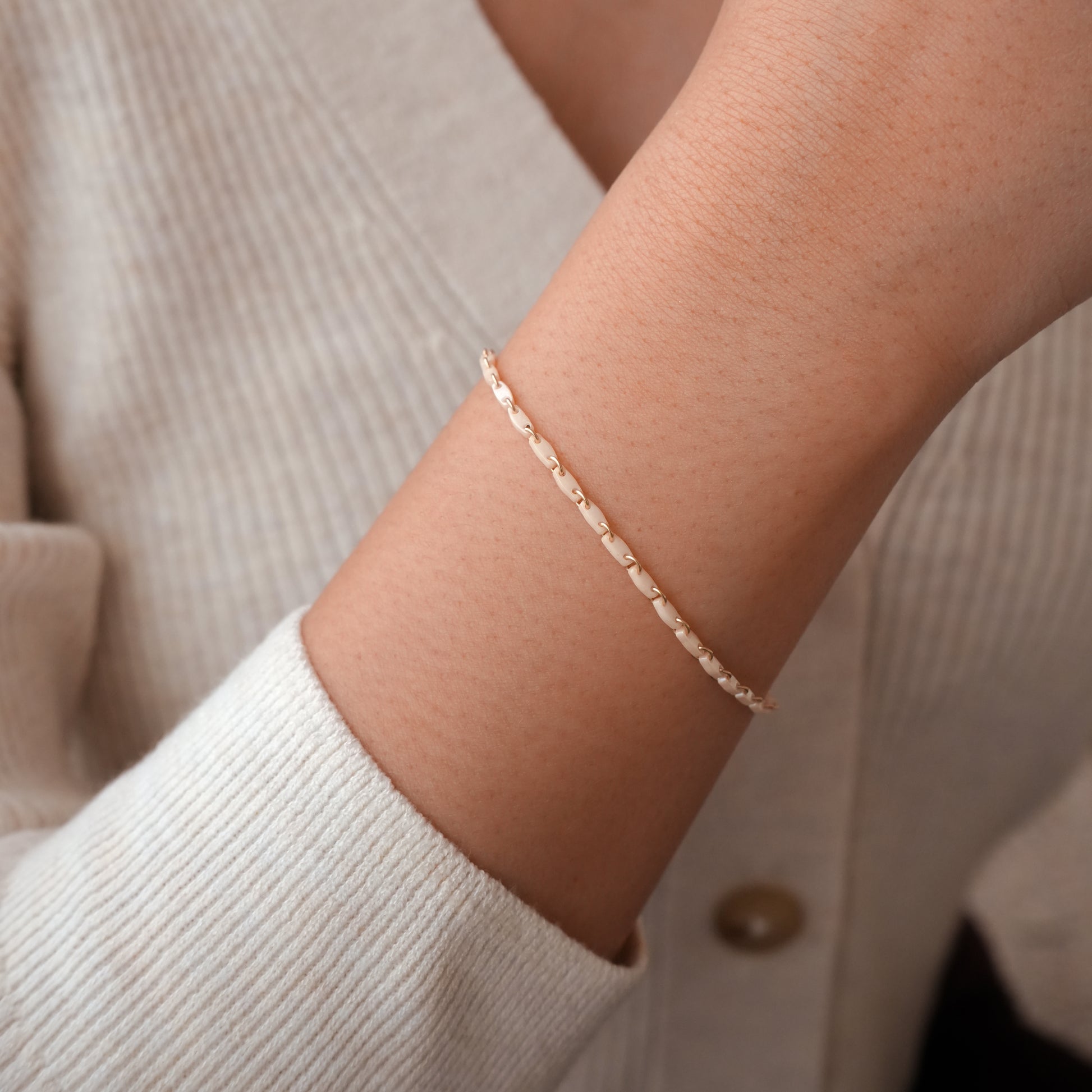 woman's wrist with one cream white beaded bracelet