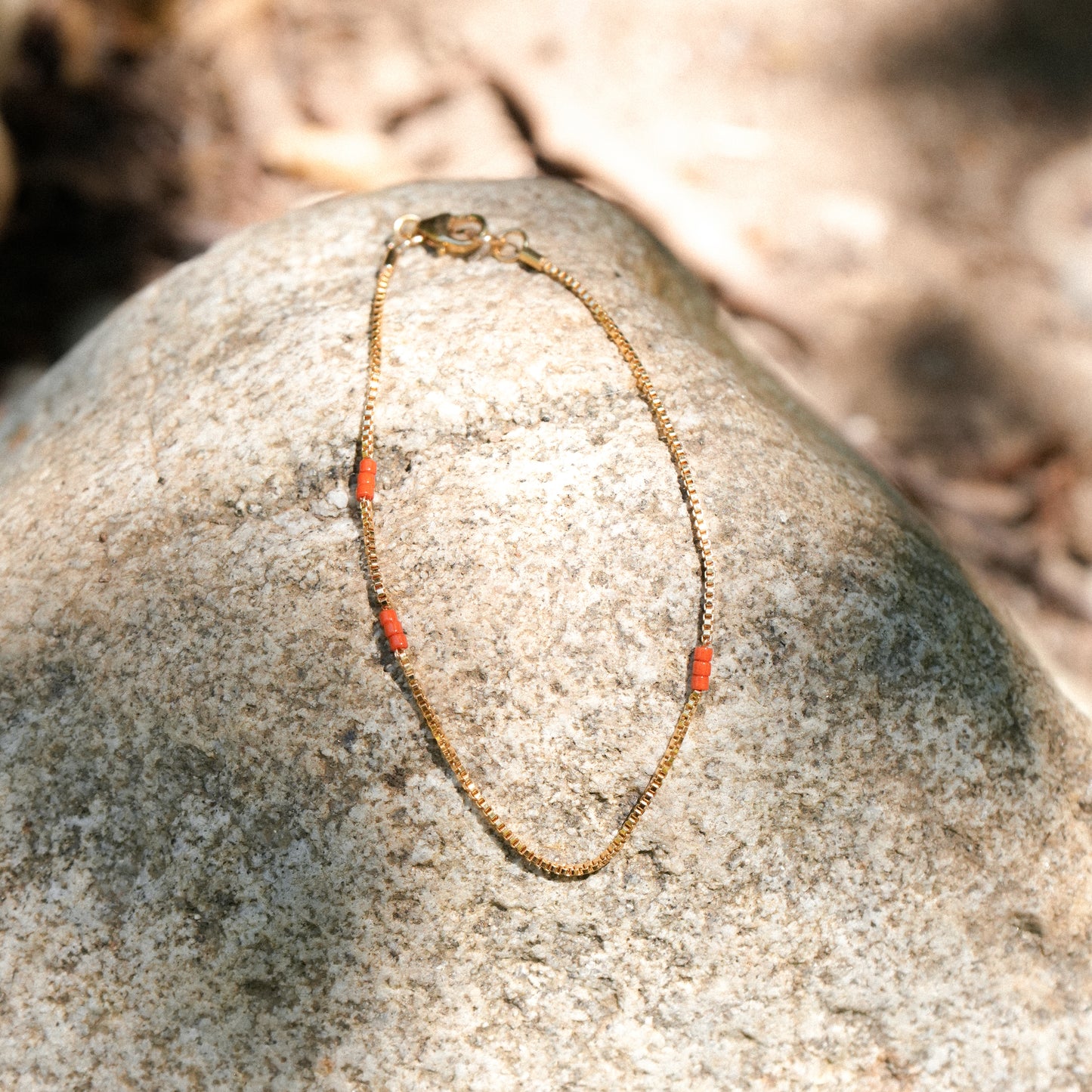 bracelet with gold-fill chain and Japanese seed beads on a boulder